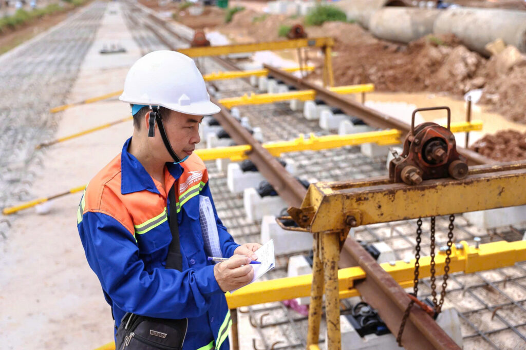 Các kỹ sư tiến hành đo đạc, căn chỉnh vị trí ray trên nền đường.